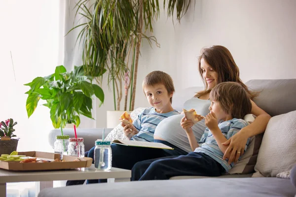Gelukkige jonge familie, zwangere moeder en twee jongens, eten lekker p — Stockfoto