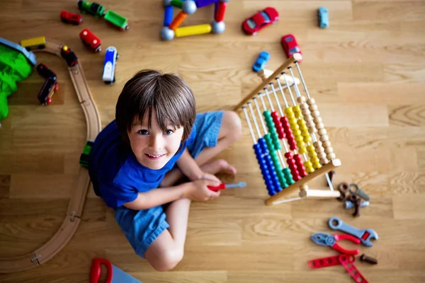 Enfant d'âge préscolaire, jouant avec un abaque et d'autres jouets, assis sur — Photo