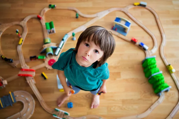 Sladký předškolní dítě, hrající s dřevěná železnici a vlaky na — Stock fotografie