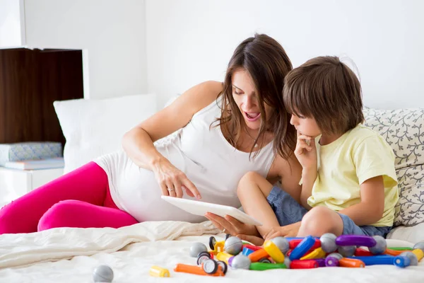 Linda madre embarazada y niño niño jugando juntos en el interior —  Fotos de Stock