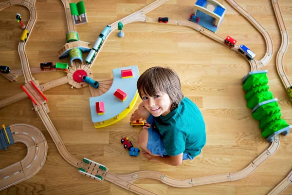 Sweet preschool child, playing with wooden railway and trains at — Stock Image Sweet preschool child, playing with wooden railway and trains at Stock Photo