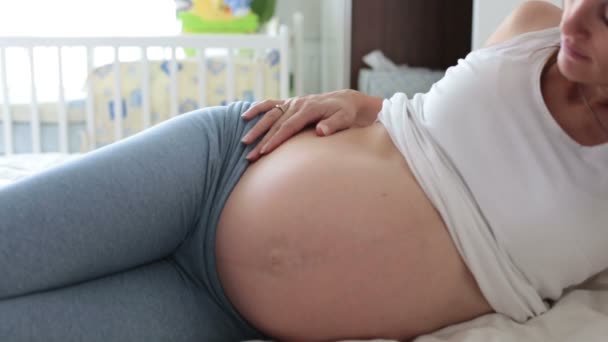 Gravid mamma och hennes son, titta på mammas mage och lyssnar till det ofödda barnet, att ha roligt tillsammans — Stockvideo
