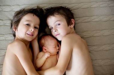 Two children, toddler and his big brother, hugging and kissing t clipart