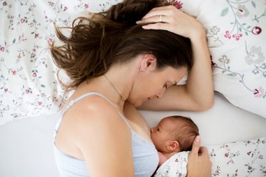 Genç breastfeeds bebeği ona Kollarındaki ve s içinde tutan, anne.