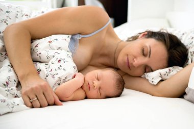 Genç anne onu tutan bebeği ile uyku