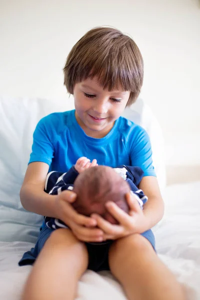 Bonito menino, irmão, encontrando-se pela primeira vez seu novo caldo de bebê — Fotografia de Stock