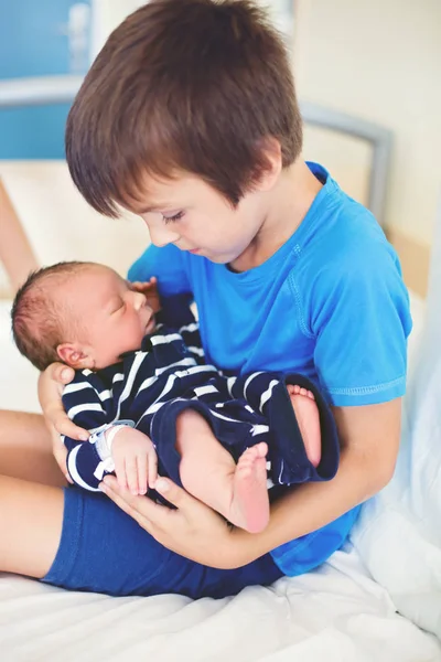 Söt pojke, bror, möte för första gången sin nya baby buljong — Stockfoto