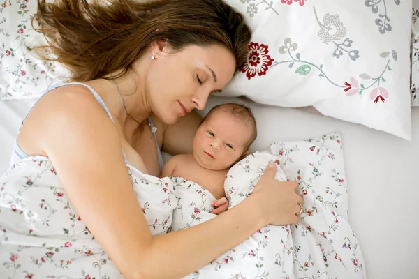 Jonge moeder liggend in bed met haar pasgeboren babyjongen — Stockfoto