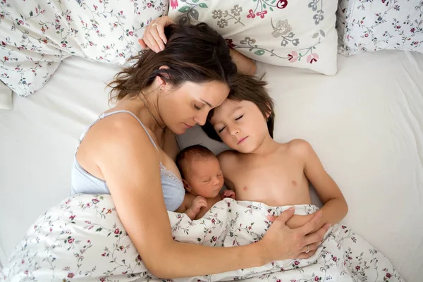 Joven madre acostada en la cama con su bebé recién nacido y su viejo —  Fotos de Stock