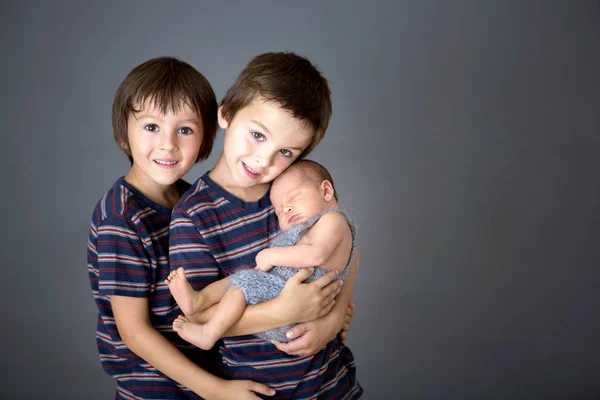Mooie jongen, knuffelen met tederheid en zorg zijn pasgeboren baby — Stockfoto