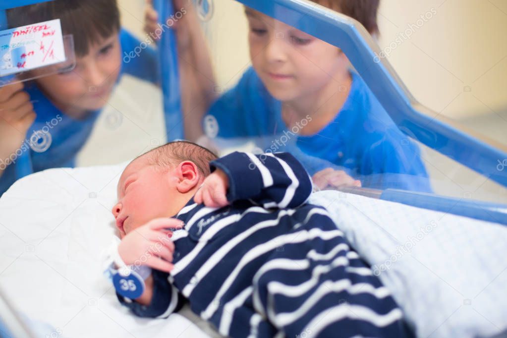 Beautiful newborn baby boy, laying in crib in prenatal hospital,