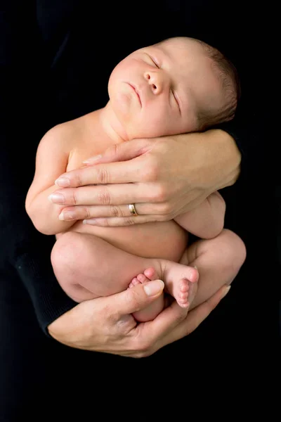 Hermoso bebé en manos de las madres, durmiendo tranquilamente — Foto de Stock