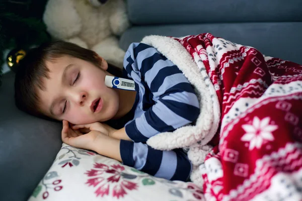 Petit enfant malade, garçon, avec une forte fièvre dormant sur le canapé à — Photo
