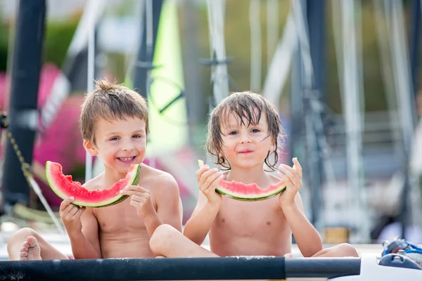 Due bambini piccoli, fratelli maschi, che mangiano anguria sul becco — Foto Stock