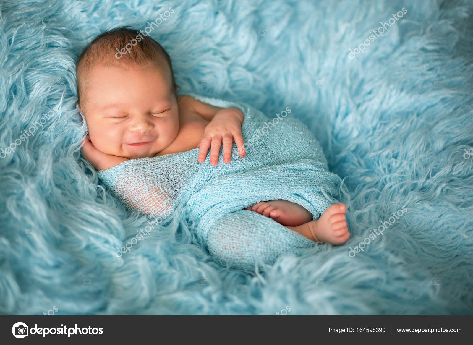 Happy smiling newborn baby in wrap, sleeping happily in cozy fur ...