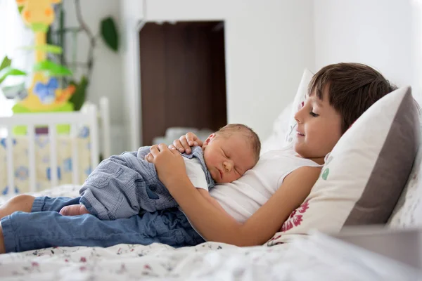 Anak yang tampan, berpelukan dengan kelembutan dan menjaga bayinya yang baru lahir — Stok Foto