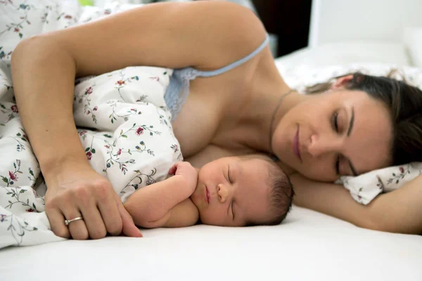 Jovem mãe dormindo com seu bebê, segurando-o — Fotografia de Stock