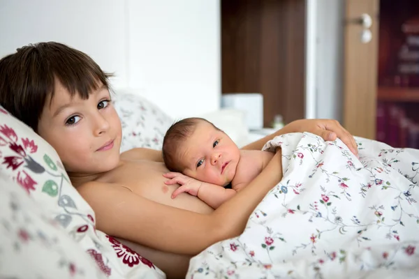 Güzel çocuk, hassasiyet ile sarılma ve onun yeni doğan Bebek Bakımı