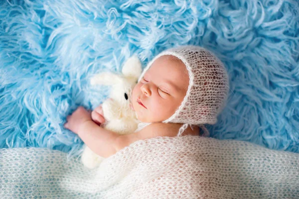 Pequeño niño recién nacido lindo, durmiendo envuelto en una envoltura blanca —  Fotos de Stock