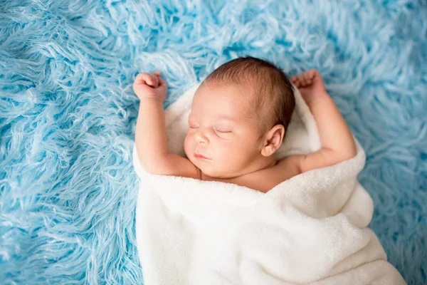 Pequeño niño recién nacido lindo, durmiendo envuelto en una envoltura blanca —  Fotos de Stock