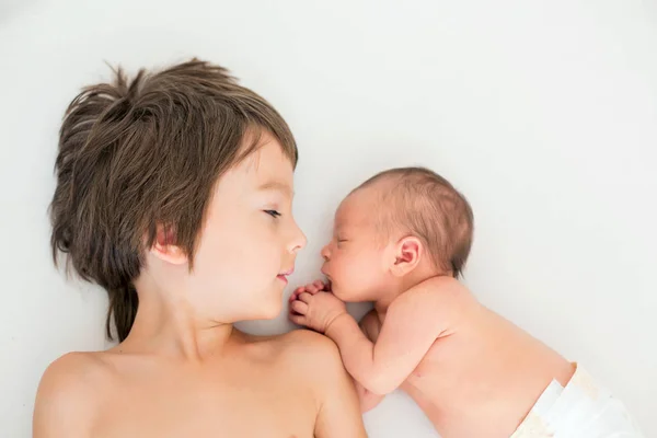 Bellissimo ragazzo, abbracciando con tenerezza e cura il suo neonato — Foto Stock