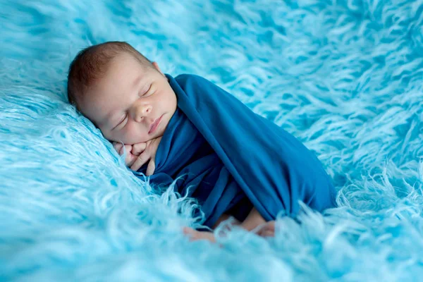 Söt baby pojke, fredligt sovande insvept i blå wrap — Stockfoto