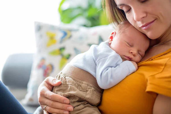 Joven madre, sosteniendo tiernamente a su bebé recién nacido — Foto de Stock