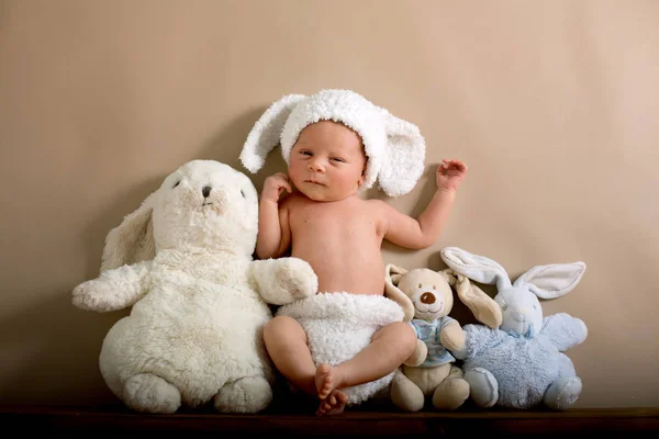 Újszülött fiú visel egy barna kötött nyúl kalapot és nadrágot, s — Stock Fotó