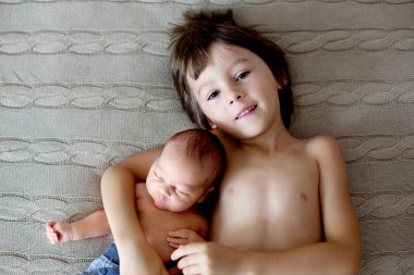 Güzel çocuk, hassasiyet ile sarılma ve onun yeni doğan Bebek Bakımı