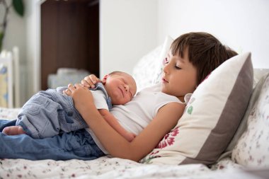 Güzel çocuk, hassasiyet ile sarılma ve onun yeni doğan Bebek Bakımı