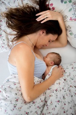 Genç breastfeeds bebeği ona Kollarındaki ve s içinde tutan, anne.