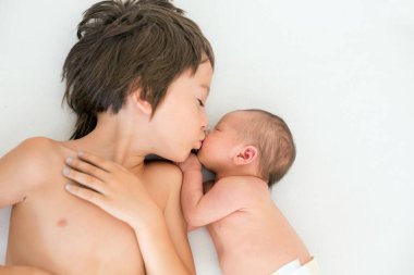 Güzel çocuk, hassasiyet ile sarılma ve onun yeni doğan Bebek Bakımı