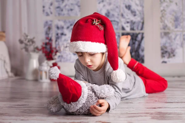 Schattige kleine jongen, spelen met weinig pluizig uil speelgoed thuis — Stockfoto