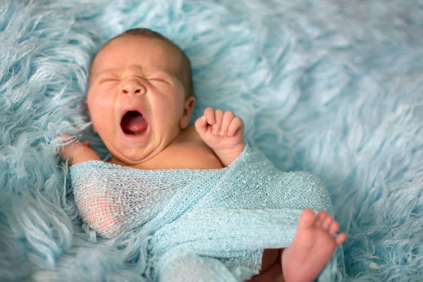 Happy smiling newborn baby in wrap, sleeping happily in cozy fur — Stock Photo, Image