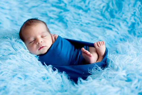 Cute baby boy, peacefully sleeping wrapped in blue wrap — Stock Photo, Image