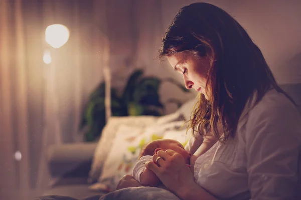 Jovem bela mãe, amamentando seu bebê recém-nascido menino em ni — Fotografia de Stock