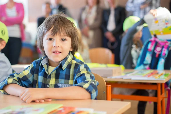 Young first grade student sitting at desk on his first day at sc — Stock Photo, Image
