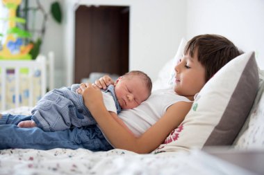 Güzel çocuk, hassasiyet ile sarılma ve onun yeni doğan Bebek Bakımı