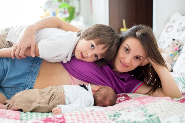 Jovem mãe amamentando seu bebê recém-nascido menino — Fotografia de Stock
