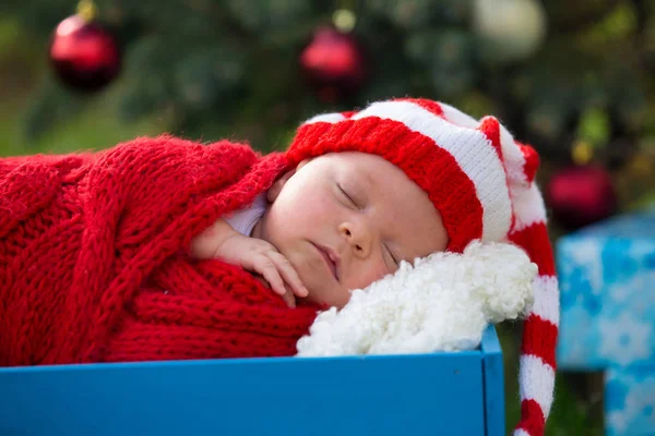 クリスマスの下で横になっているサンタ服で生まれたばかりの赤ちゃんの肖像画 — ストック写真