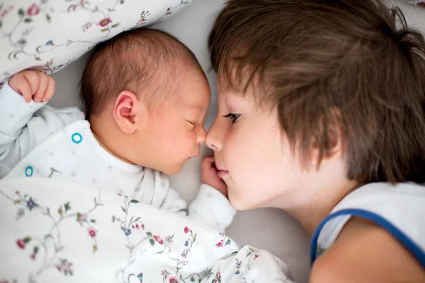 BLindo menino, abraçando com ternura e cuidar de seu bab recém-nascido — Fotografia de Stock