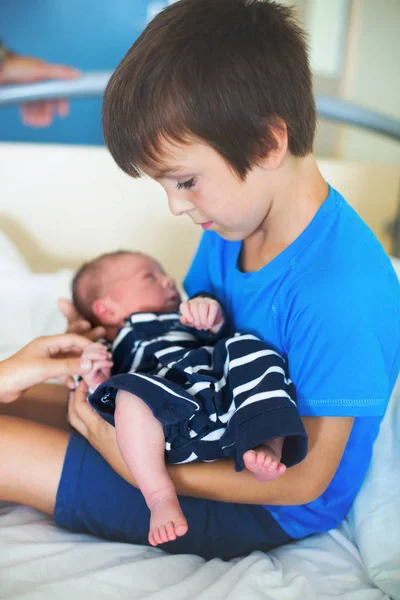 Милый мальчик, братец, впервые встречается со своим новым детским бульоном — стоковое фото