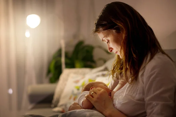 Jovem bela mãe, amamentando seu bebê recém-nascido menino em ni — Fotografia de Stock