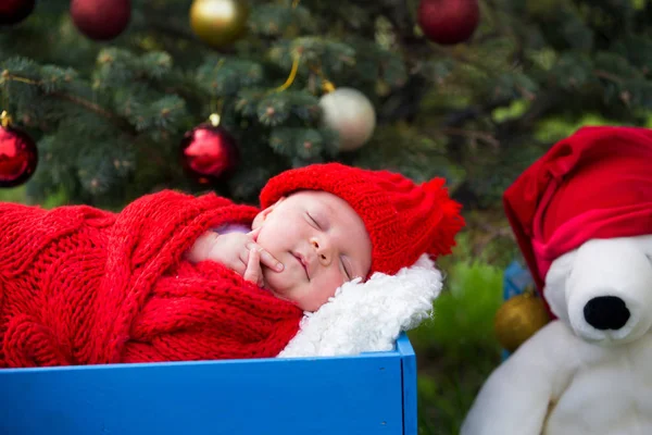 Porträt eines neugeborenen Babys in Weihnachtsmannkleidung, das unter Weihnachten liegt — Stockfoto