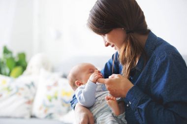 Genç anne, onun yeni doğan bebek çocuk evde öpüşme