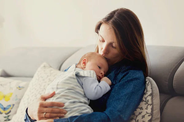 Νεαρή μητέρα, φιλώντας το νεογέννητο μωρό αγόρι της στο σπίτι — Φωτογραφία Αρχείου