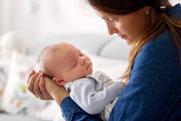 Fiatal anya, kissing neki újszülött fiú otthon — Stock Fotó