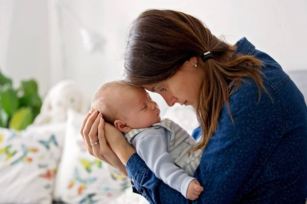 Jonge moeder, zoenen haar pasgeboren babyjongen thuis — Stockfoto