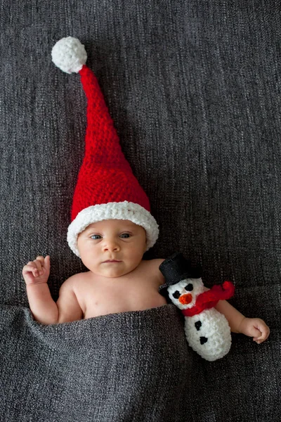 少し眠っている新生児男の子、サンタの帽子をかぶって押し — ストック写真