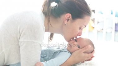 Mutlu anne okşayarak ve öpüşme onu, aile kavramı, anne sevişme yeni doğan bebek yeni doğan oğluna,